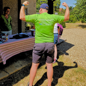 A man poses for the camera showing the back of his t-shirt with the text I'm fundraising for Autism Early Support.